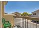 Balcony with green chairs overlooking street and neighboring houses on a sunny day at 5536 Baccarat Ave # 101, Las Vegas, NV 89122