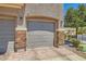 Attached garage featuring stone accents and a brick driveway, adding curb appeal to the property at 5536 Baccarat Ave # 101, Las Vegas, NV 89122