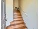 Wooden staircase leading to upper level with white handrail and neutral walls at 5536 Baccarat Ave # 101, Las Vegas, NV 89122