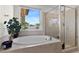 Luxurious bathroom featuring a soaking tub and a glass shower at 8107 Skye Sweep St, Las Vegas, NV 89166