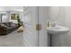 Chic half bathroom with a modern pedestal sink, complemented by the view of a comfortable living room at 8107 Skye Sweep St, Las Vegas, NV 89166