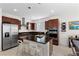 Modern kitchen boasts stainless steel appliances, a functional island, and dark wood cabinets at 8107 Skye Sweep St, Las Vegas, NV 89166