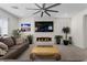 Comfortable living room featuring a stone accent wall with fireplace and large ceiling fan at 8107 Skye Sweep St, Las Vegas, NV 89166
