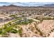 Wide aerial view of a neighborhood with parks, playgrounds, landscaping and mountain views in the distance at 10085 S Riley St, Las Vegas, NV 89178