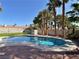 A beautiful backyard featuring a pool with lush artificial turf and palm trees at 2022 Big Bend Way, Henderson, NV 89074