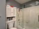 Bathroom with a glass-door shower over tub and a built-in storage cabinet at 2022 Big Bend Way, Henderson, NV 89074