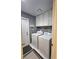 Laundry room with white washer, dryer, cabinets, door, and tiled flooring at 2022 Big Bend Way, Henderson, NV 89074
