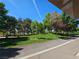 Scenic park view featuring lush green grass, mature trees, and a paved walking path under a bright blue sky at 2022 Big Bend Way, Henderson, NV 89074