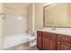 Bright bathroom featuring cherry vanity, white countertop, shower over tub, and tile floors at 2489 Black River Falls Dr, Henderson, NV 89044