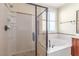 Bathroom with soaking tub, glass enclosed shower, and neutral tile at 2489 Black River Falls Dr, Henderson, NV 89044