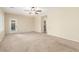 Empty bedroom with neutral carpet, ceiling fan and bright windows with plantation shutters at 2489 Black River Falls Dr, Henderson, NV 89044