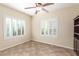 This neutral bedroom features tile floors, two windows with white shutters, and ceiling fan at 2489 Black River Falls Dr, Henderson, NV 89044