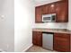Kitchenette features granite countertop, fridge, microwave, and wood cabinets at 2489 Black River Falls Dr, Henderson, NV 89044