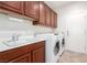 Laundry room featuring built in cabinets, sink and white appliances at 2489 Black River Falls Dr, Henderson, NV 89044