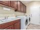 Convenient laundry room featuring updated washer and dryer, granite countertop and ample storage at 2489 Black River Falls Dr, Henderson, NV 89044