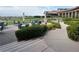 Beautiful patio with chairs, umbrellas, trimmed bushes, and a building in the background at 2489 Black River Falls Dr, Henderson, NV 89044