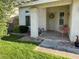 Charming front porch with seating, mature landscaping, and a decorative front door, enhancing curb appeal at 2807 Camelback Ln, Henderson, NV 89074
