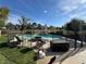Backyard view of a refreshing in-ground pool with surrounding patio, fence, fire pit, and lounge furniture at 2807 Camelback Ln, Henderson, NV 89074