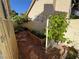 Enclosed side yard with a garden bed, trellis, and stone pathway, creating a charming and private outdoor space at 2807 Camelback Ln, Henderson, NV 89074