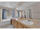 Bright bathroom features a double sink vanity, tub, and large mirror at 6536 Castor Tree Way, Las Vegas, NV 89108