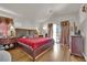 Comfortable bedroom with wood floors, slider to the balcony, and neutral color palette at 6536 Castor Tree Way, Las Vegas, NV 89108