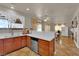 Open kitchen design with wooden cabinets, dishwasher, and breakfast bar at 6536 Castor Tree Way, Las Vegas, NV 89108