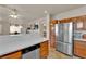 Kitchen featuring stainless steel fridge, wooden cabinets, and breakfast bar at 6536 Castor Tree Way, Las Vegas, NV 89108