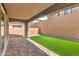Back patio featuring brick flooring, artificial turf and a brick wall, creating an inviting outdoor living space at 89 Oratorio Dr, Henderson, NV 89015