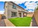 Landscaped backyard featuring artificial turf, a covered patio, and a neutral-toned exterior, ideal for low-maintenance living at 89 Oratorio Dr, Henderson, NV 89015