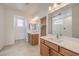 Bright bathroom featuring double vanities, tile flooring, modern lighting, and a glass-enclosed shower at 89 Oratorio Dr, Henderson, NV 89015