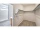Walk-in closet with carpet, wire shelving, and an adjacent ensuite bathroom at 89 Oratorio Dr, Henderson, NV 89015