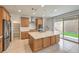 Bright kitchen features an island, stainless steel appliances, and sliding door access to the outdoor space at 89 Oratorio Dr, Henderson, NV 89015