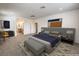 Bright main bedroom with neutral carpet, a gray platform bed, ensuite bath, and stylish decor at 89 Oratorio Dr, Henderson, NV 89015