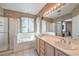 Bathroom with double vanity, bathtub, and glass shower enclosure, with neutral color scheme at 8942 Galena Crossing St, Las Vegas, NV 89123