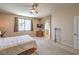 Bright bedroom with carpet, ceiling fan, and an archway leading to the en-suite bathroom at 8942 Galena Crossing St, Las Vegas, NV 89123