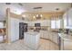 Bright kitchen featuring white cabinets, black appliances, and a center island with marble countertop at 8942 Galena Crossing St, Las Vegas, NV 89123