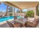 Inviting covered patio with cozy seating area overlooking the sparkling swimming pool and landscaped backyard at 8942 Galena Crossing St, Las Vegas, NV 89123