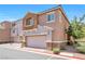 Stylish two-story townhome showcasing a stucco exterior, two-car garage, and desert-friendly landscaping at 9981 Sable Point St, Las Vegas, NV 89178