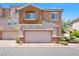 Charming two-story townhome featuring a stucco facade, two-car garage and well-maintained landscaping at 9981 Sable Point St, Las Vegas, NV 89178