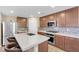 Kitchen featuring an island with seating, stainless steel appliances, and rich wood cabinetry, perfect for cooking and entertaining at 9981 Sable Point St, Las Vegas, NV 89178