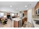 Modern kitchen featuring stainless steel appliances, countertops, and an island, seamlessly flowing into the cozy living area at 9981 Sable Point St, Las Vegas, NV 89178