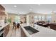 Open-concept kitchen featuring a large island with seating, stainless faucet, and stylish finishes, adjacent to the dining and living area at 9981 Sable Point St, Las Vegas, NV 89178
