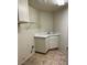 Bright laundry room with a sink, storage, and tile flooring at 1003 Dover Glen Dr, North Las Vegas, NV 89031