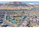 Community aerial view with a pool, clubhouse, tennis courts, lush greenery, and mountain views at 10150 Emerald Sunset Ct, Las Vegas, NV 89148