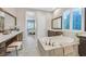 Elegant bathroom featuring a large soaking tub, dual vanities, and stylish tile work at 10150 Emerald Sunset Ct, Las Vegas, NV 89148