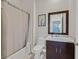 Cozy bathroom featuring a shower-tub combo, a single sink vanity with a dark wood cabinet and a decorative mirror at 10150 Emerald Sunset Ct, Las Vegas, NV 89148