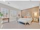 Spacious primary bedroom with a four-poster bed, plantation shutters, and a sitting area at 10150 Emerald Sunset Ct, Las Vegas, NV 89148