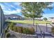 Beautifully landscaped common area featuring lush lawn, mature tree, and a decorative stone wall at 10150 Emerald Sunset Ct, Las Vegas, NV 89148
