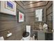 Chic powder room with wood paneled accent wall, unique glass sink, and modern fixtures at 10150 Emerald Sunset Ct, Las Vegas, NV 89148