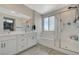 Well-lit bathroom featuring double sinks, a soaking tub, and a glass-enclosed shower at 10172 Fire Skye Ave, Las Vegas, NV 89166